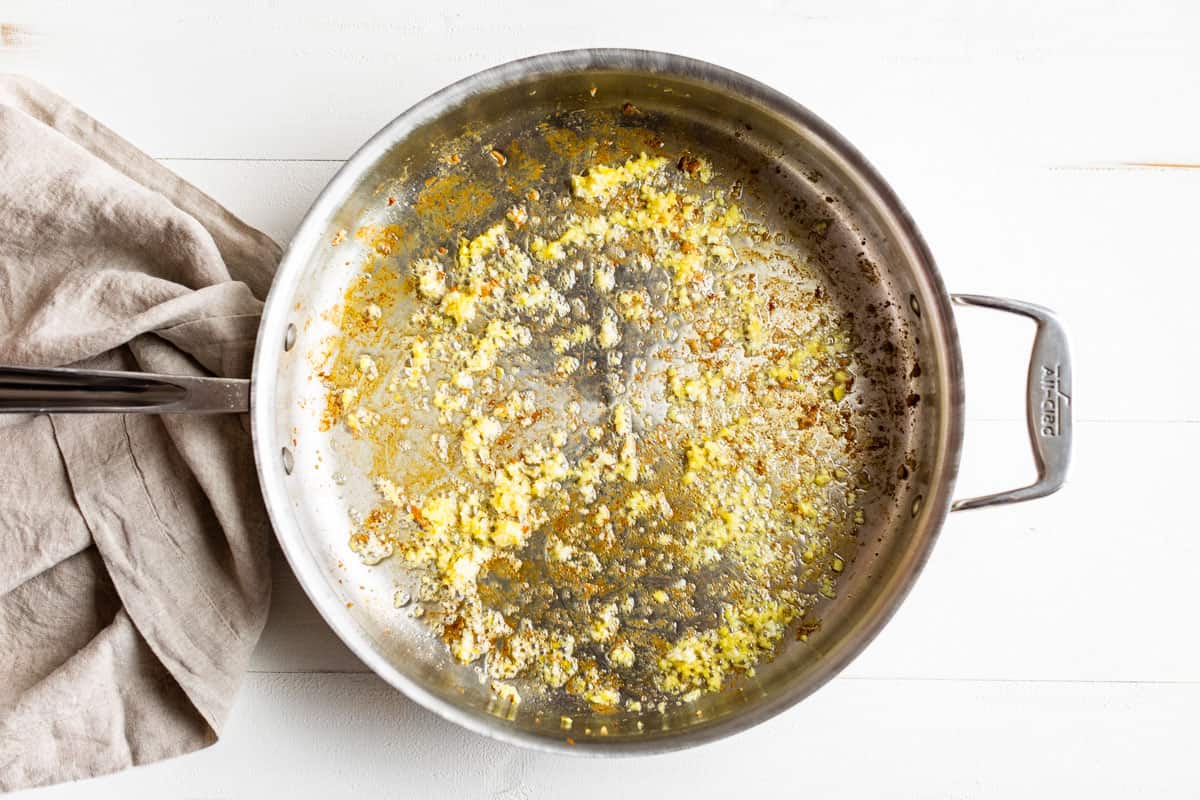 Sautéing the ginger and garlic in a large skillet.