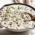 Finished Ground Beef Stroganoff in a white skillet sprinkled with parsley.