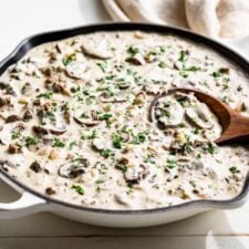 Finished Ground Beef Stroganoff in a white skillet sprinkled with parsley.