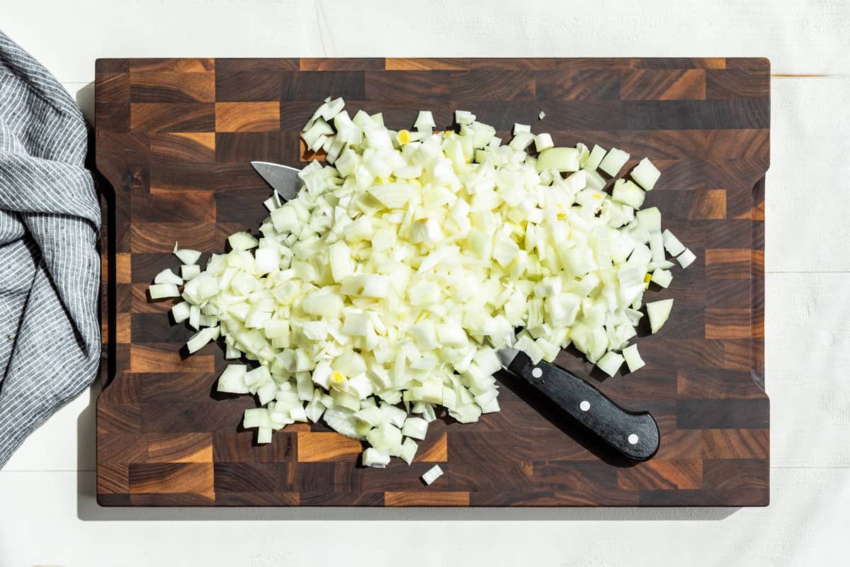 Diced onion on a wood cutting board.