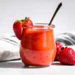Strawberry Vinaigrette in a clear glass jar with strawberry garnishes.