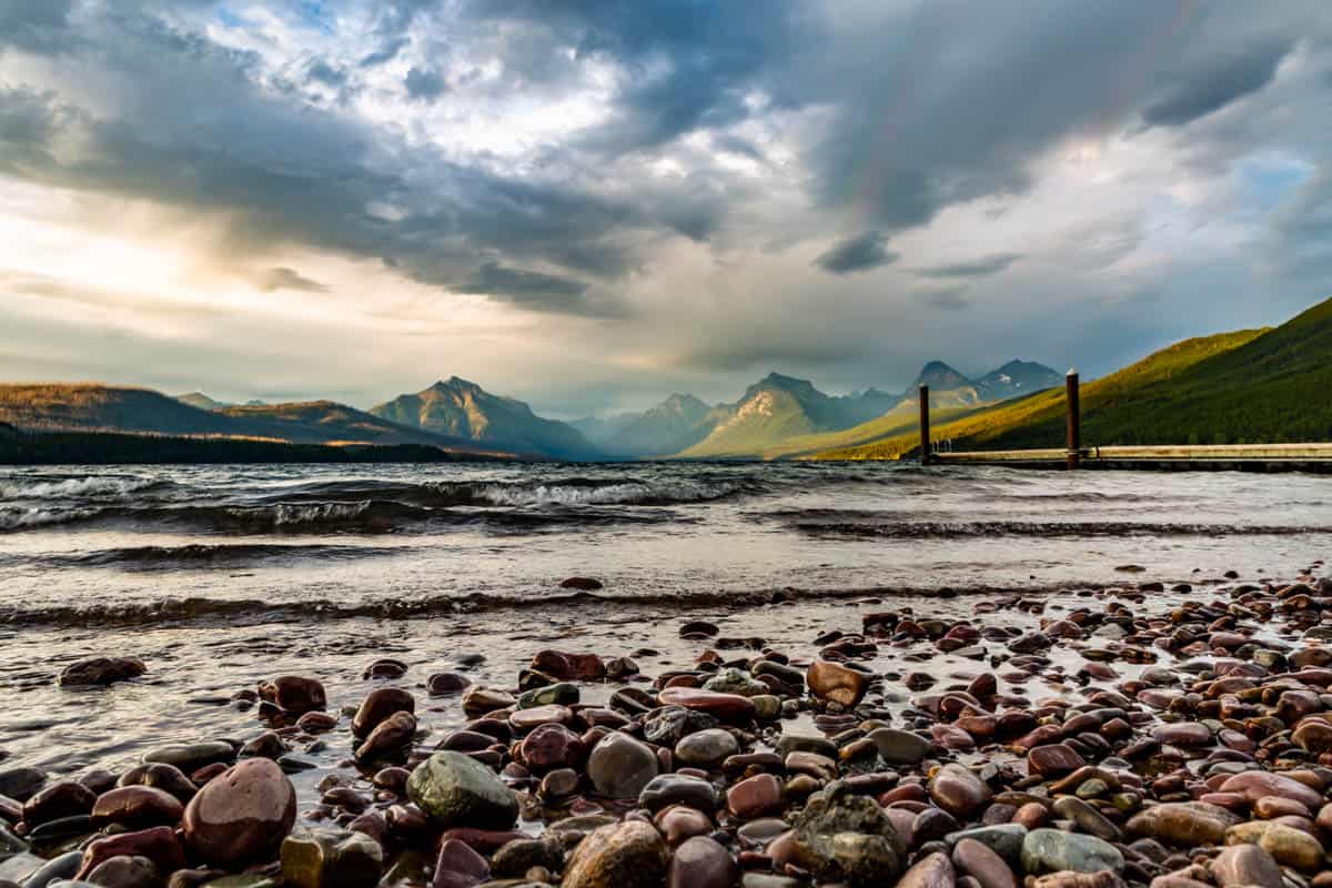 View from the Lake McDonald with the dock in the distance and a stormy sunset happening.