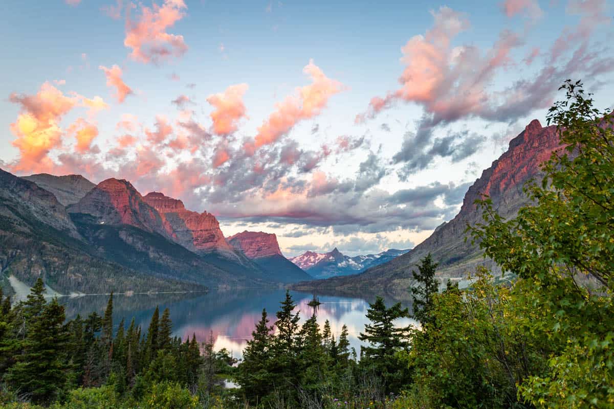 Early pink sunrise overlooking St Mary's lake with Wild Goose Island in the center.