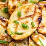 Close macro view of the finished grilled potatoes tossed with the butter and green onions.