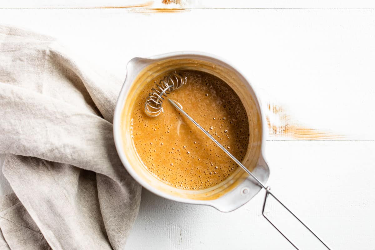 The Honey Mustard Sauce whisked together in a small bowl on a white background.