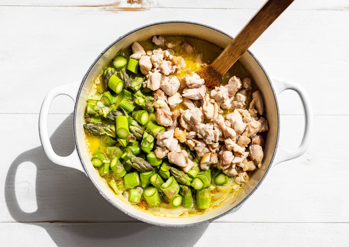 Adding the chicken and asparagus back to the pot with the green curry.