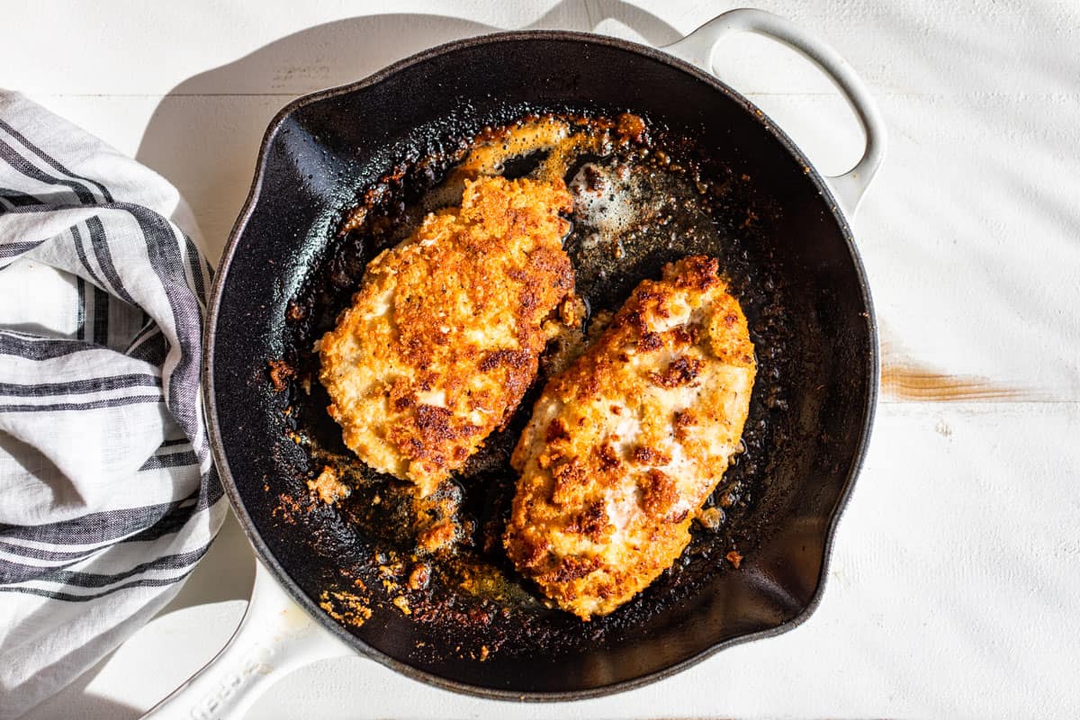 Pan frying the breaded chicken cutlets in a skillet.