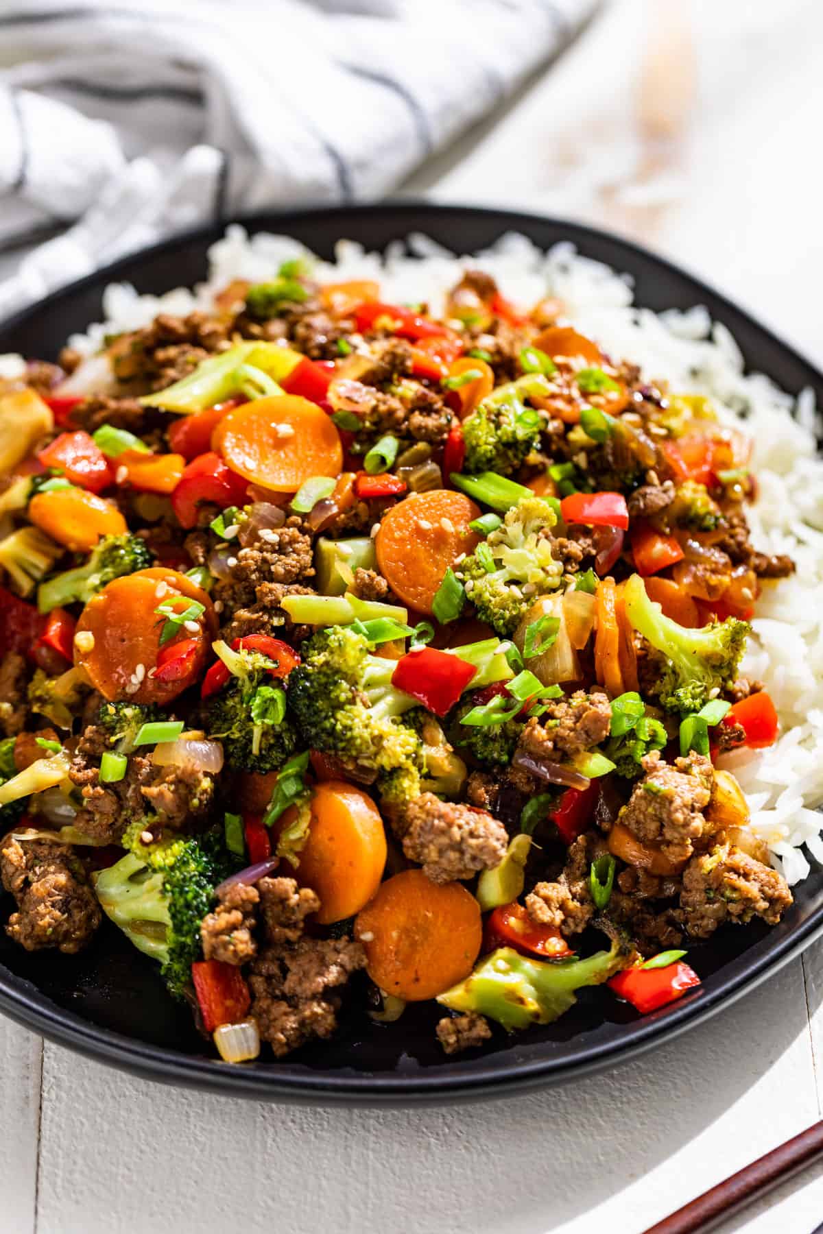 Ground Beef Stir Fry served on a black plate with freshly steamed rice.