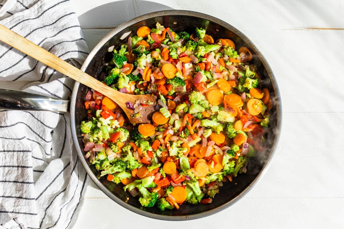 Veggies for the stir fry being sautéed in a large skillet.