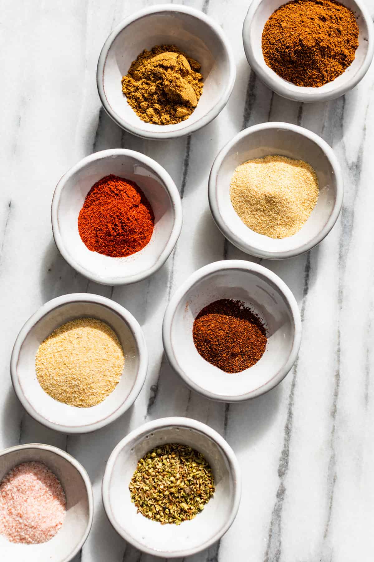 Straight down view of each spice measured out and in small prep bowls.