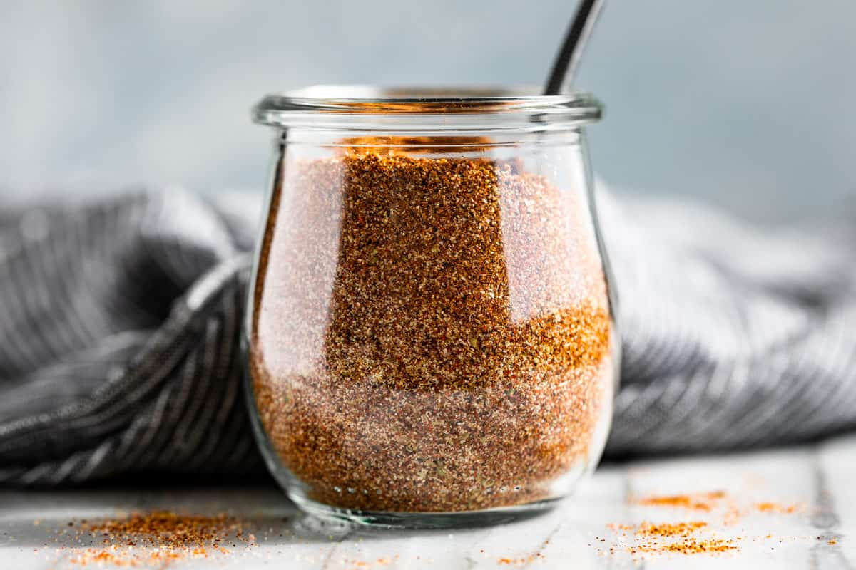 Fajita Seasoning mixed together and in a glass jar with a silver spoon in it.