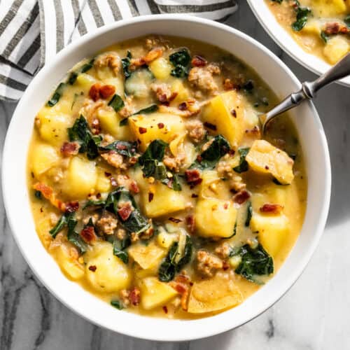 Finished Instant Pot Zuppa Toscana in white serving bowls with a silver spoon in 1 bowl.