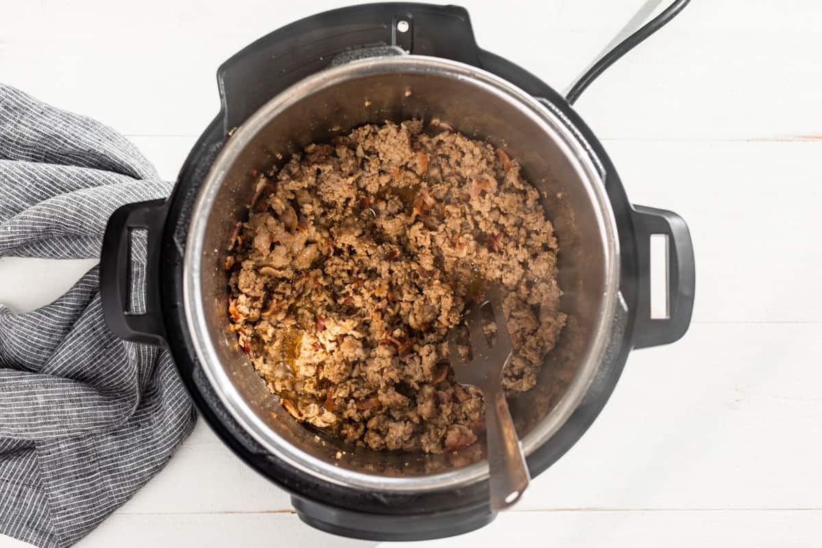 Sautéing the sausage and bacon in an Instant Pot.