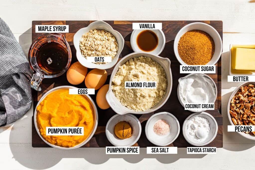 All the ingredients for Pumpkin Crisp, pumpkin purée, coconut milk, coconut sugar, pecans, almond flour, oats, maple syrup, pumpkin spice, butter, and vanilla extract.