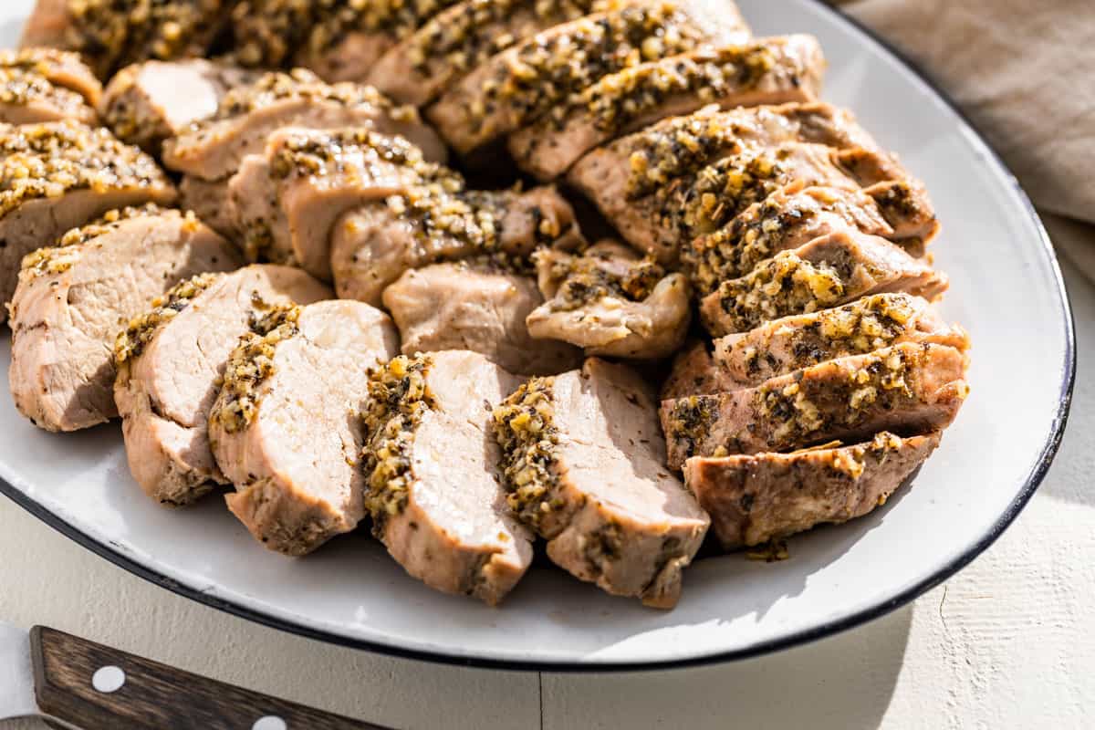 Sliced baked Pork Tenderloin arranged on a serving platter.