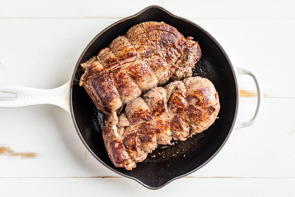 Searing the tied Beef Tenderloin roasts in a cast iron skillet.