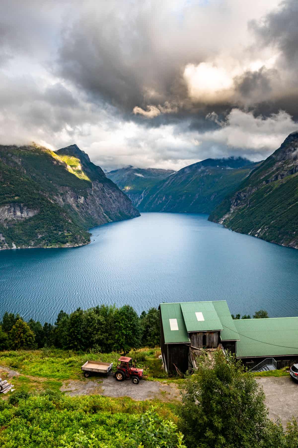 Sunset view over a fjord in Norway with a farmhouse in the foreground.