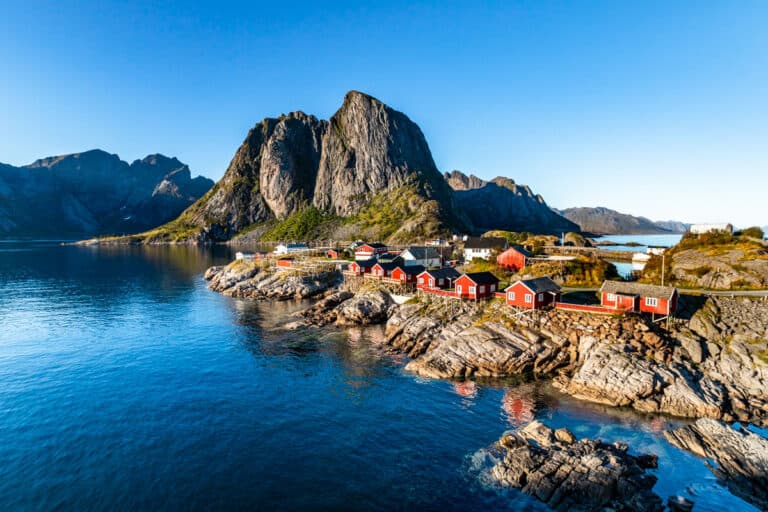Red fishing houses on the edge of the water in the classic view of Hamnoy, Norway.