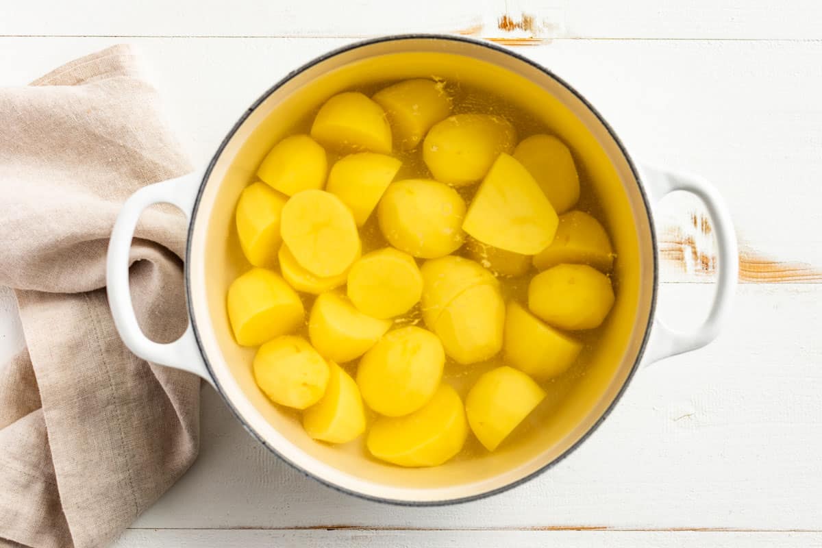 Cut up potatoes in a large white pot covered with water.