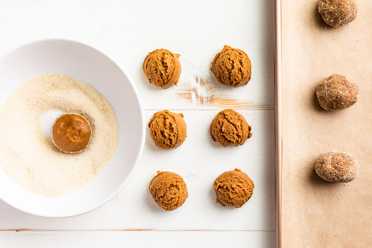 Portioning out the cookie dough, rolling into balls, and coating them in sugar.