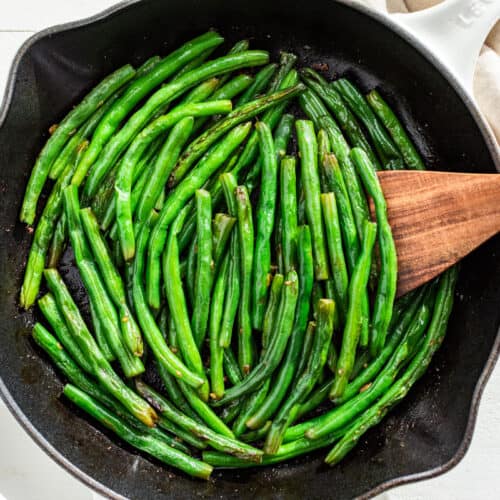 Green Beans finished with the butter and garlic in a white skillet.