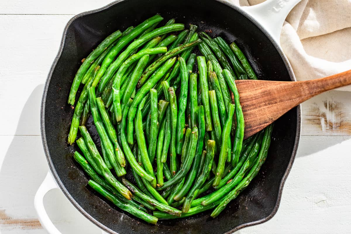 Green Beans finished with the butter and garlic in a white skillet.