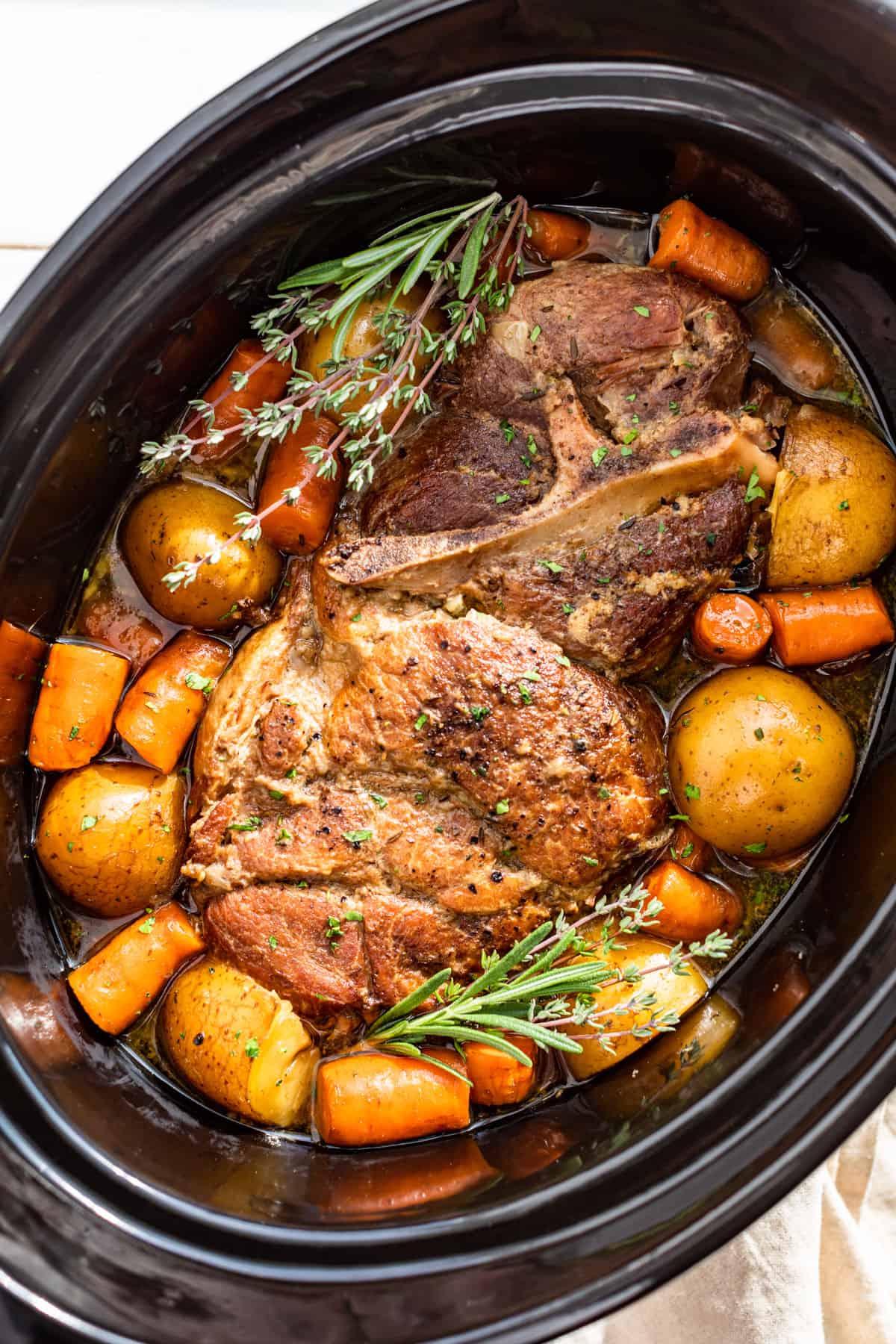 Downwards view of Slow Cooker Pork Roast with potatoes and carrots in the slow cooker bowl.