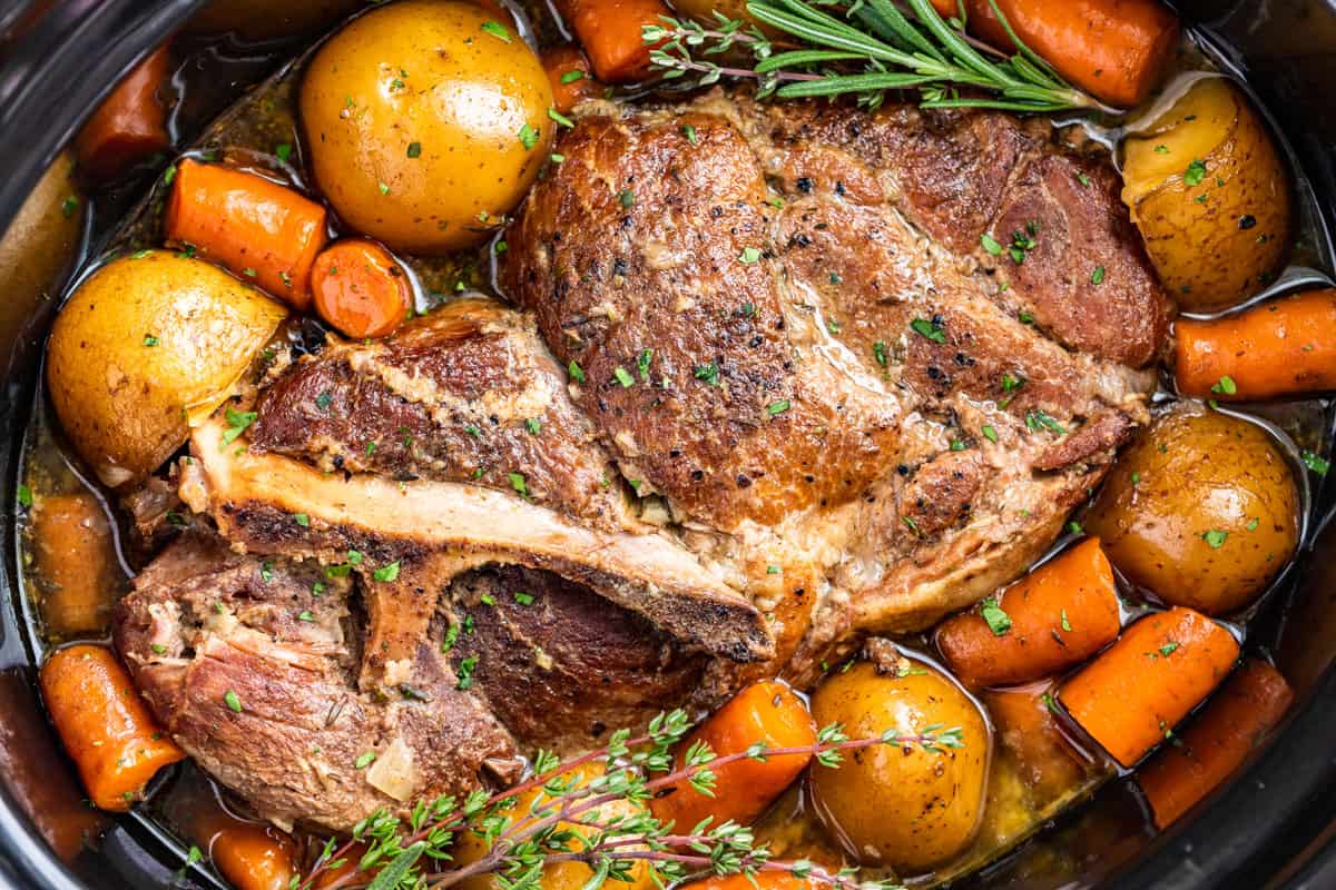 Close up macro shot of the finished Slow Cooker Pork Roast surrounded by carrots and potatoes.