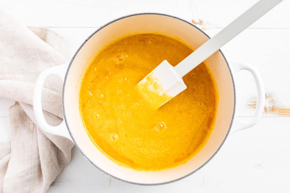 Mixing the egg yolks together with the sugar in a cooking pot.