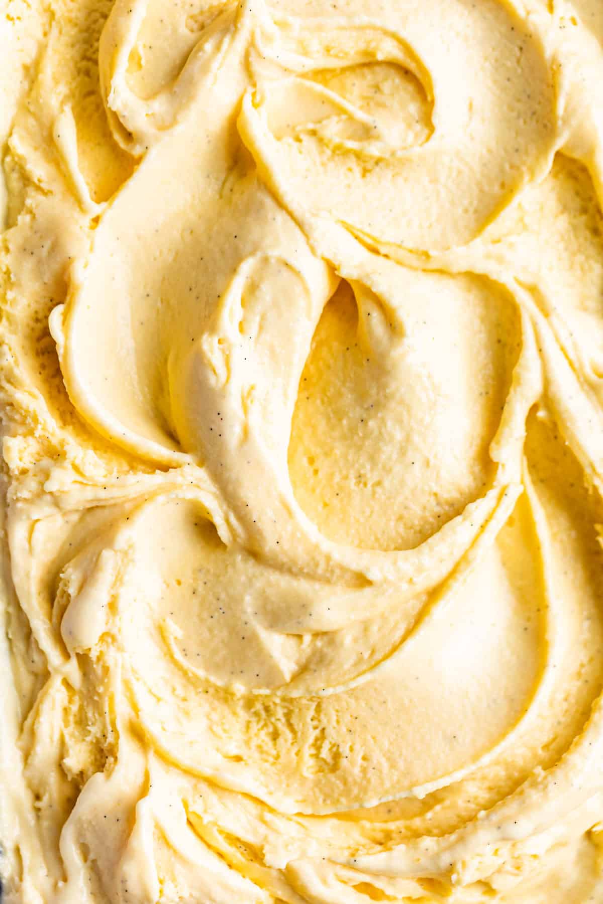 Close macro shot of soft serve vanilla ice cream with swirls.