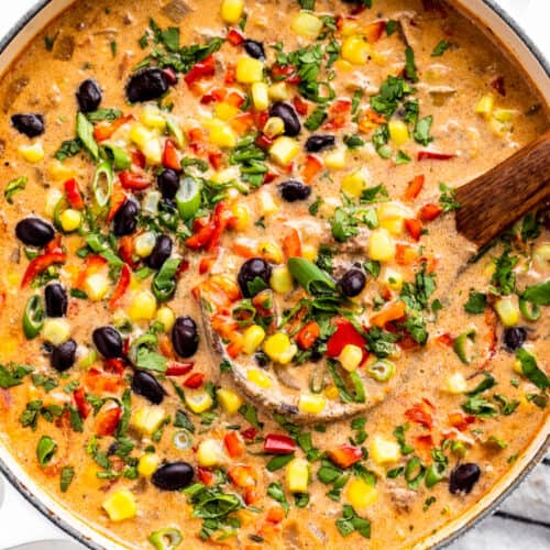 Creamy Taco Soup in a white pot with a wood ladle.