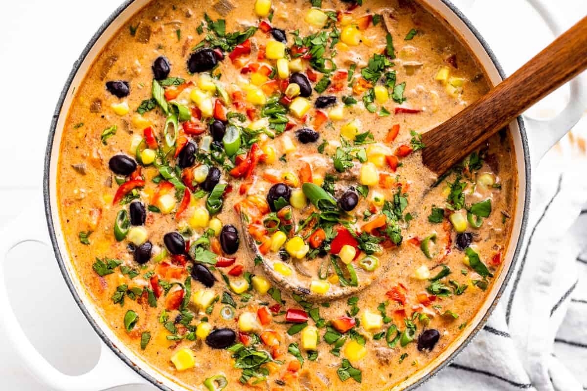 Creamy Taco Soup in a white pot with a wood ladle.