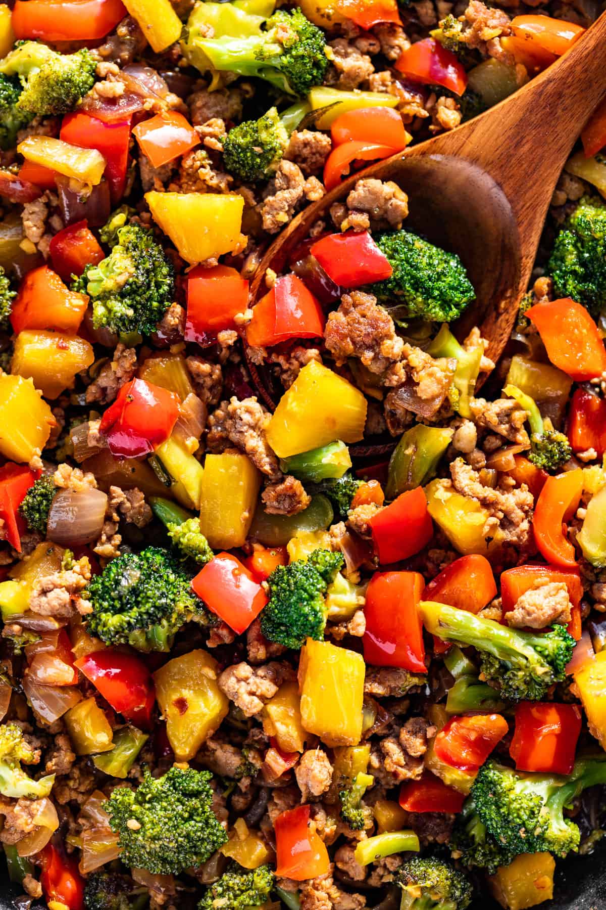 Close macro view of Ground Pork Stir Fry with a wood spoon in it.