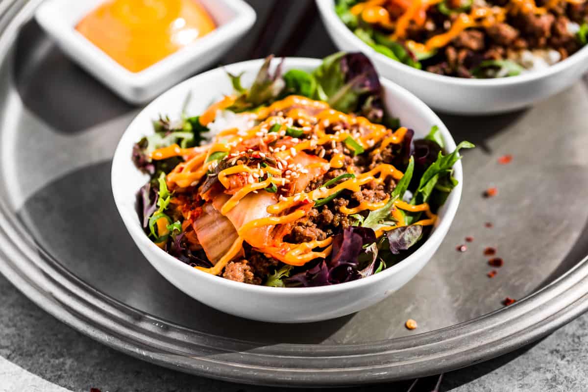 Side view of finished Korean Ground Beef Bowls on a silver tray.