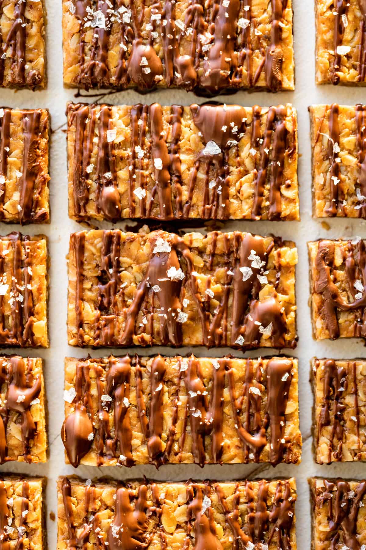 Straight down view of Peanut Butter Granola Bars drizzled with chocolate and sprinkled with sea salt.