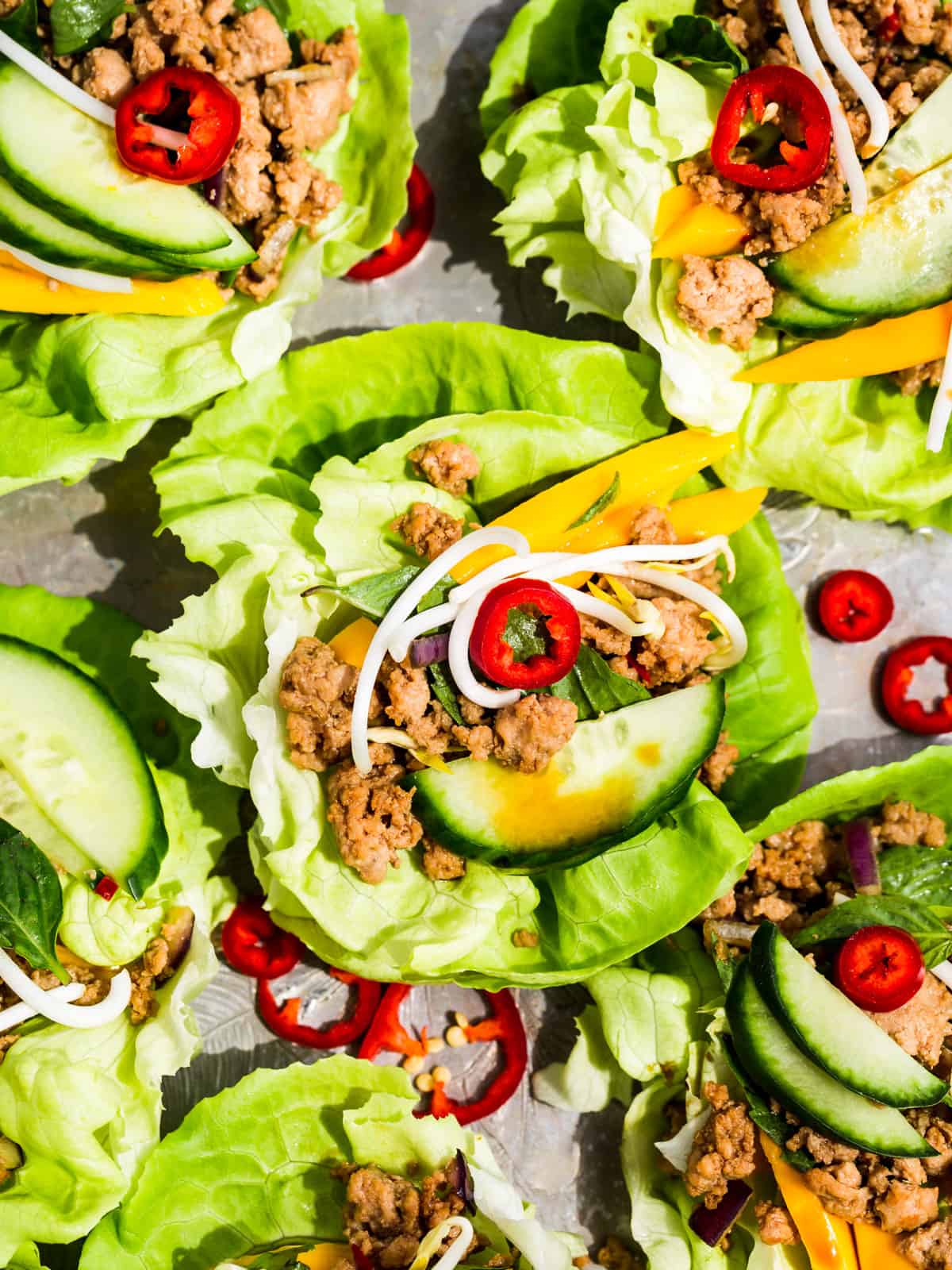 Thai Turkey Lettuce Wraps topped with mango, cucumber, bean sprouts, and sliced chilis.