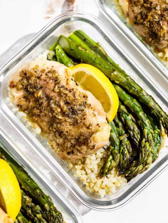 Straight down view of Garlic Chicken with asparagus and cauliflower rice in glass meal prep containers.