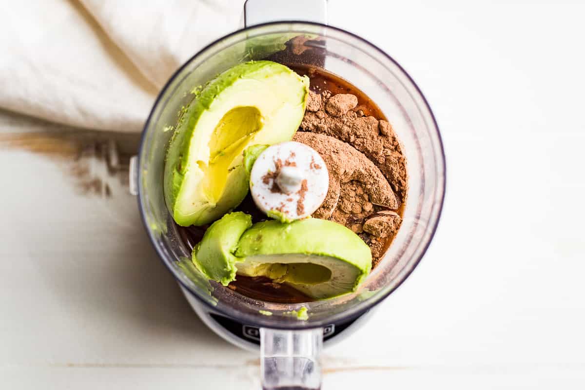 Avocado, cocoa powder, maple syrup, and vanilla extract in a food processor.