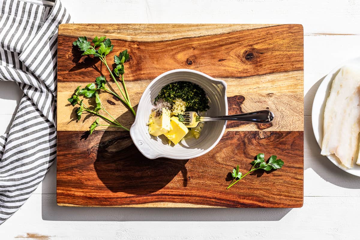 Mashing the butter, olive oil, and herbs together for the baked cod.