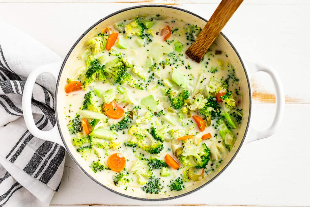 Adding the cream and broccoli to the soup pot.