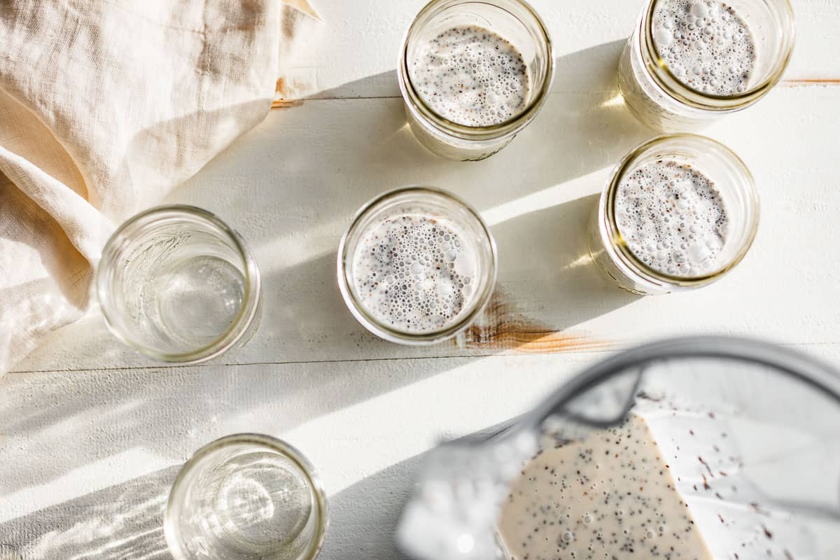 The Creamy Coconut Chia Pudding being portioned out into 1 cup mason jars.