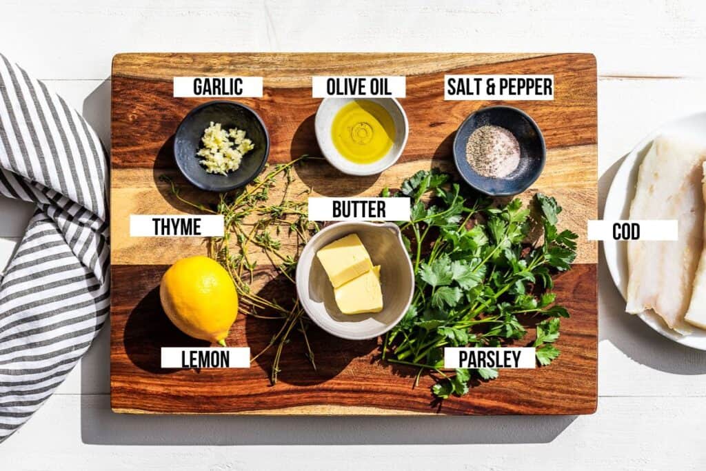 All the ingredients for the Lemon Cod prepped and on a wooden cutting board.