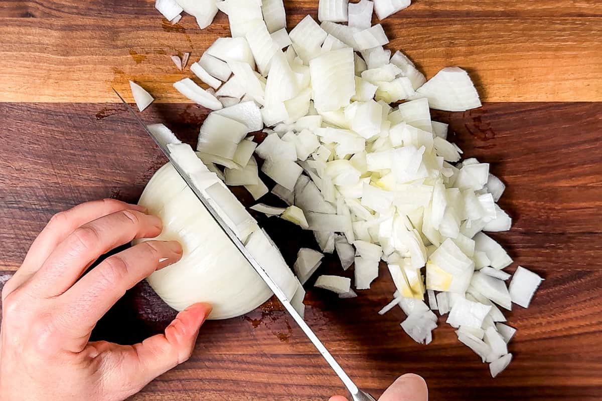 Dicing an onion on a wood cutting board,