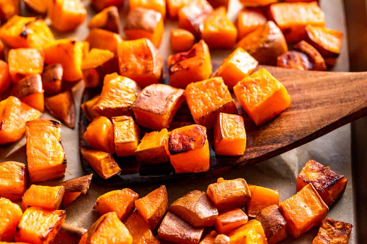 Finished roasted sweet potatoes with a wood spatula.