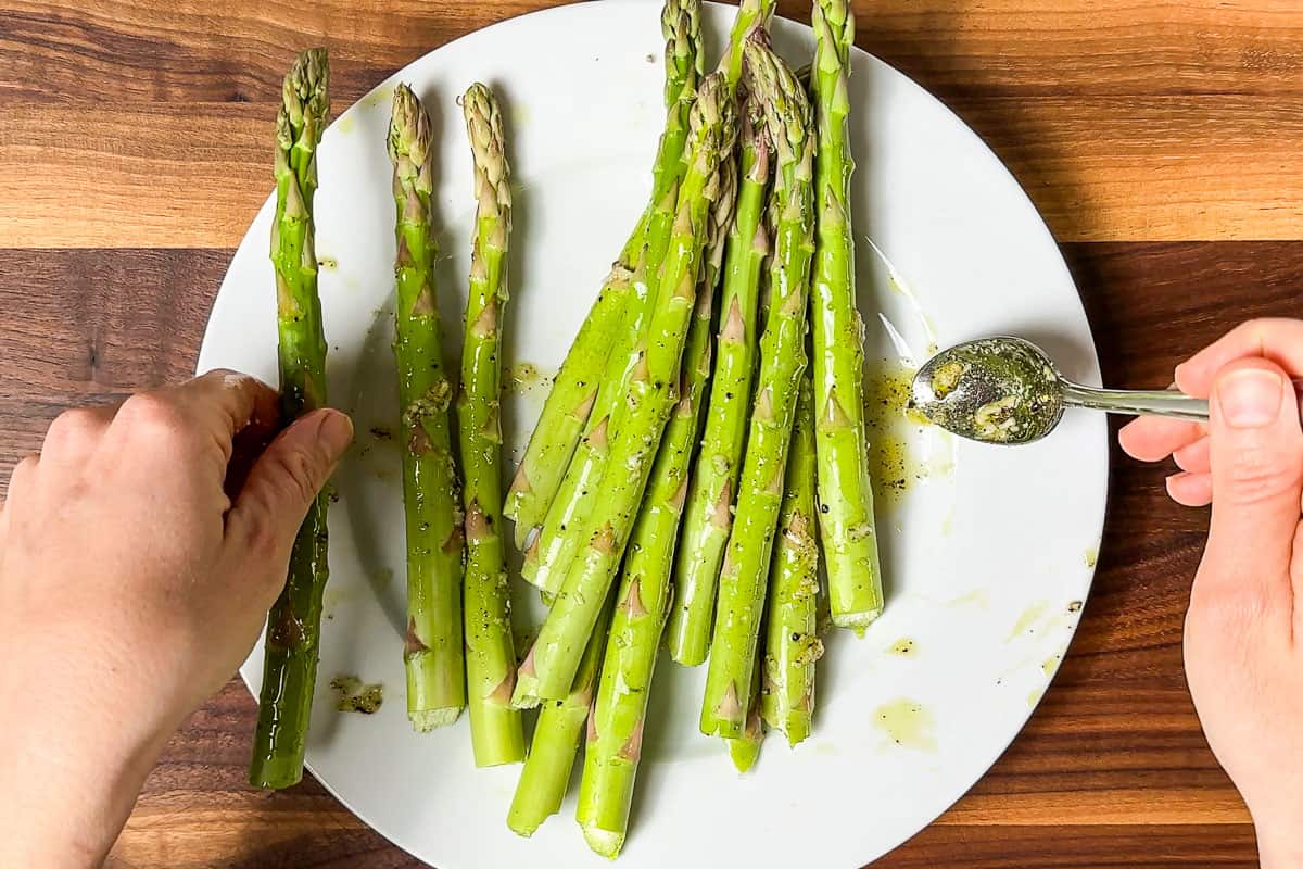 Tossing the asparagus spears together with the olive oil garlic mixture.