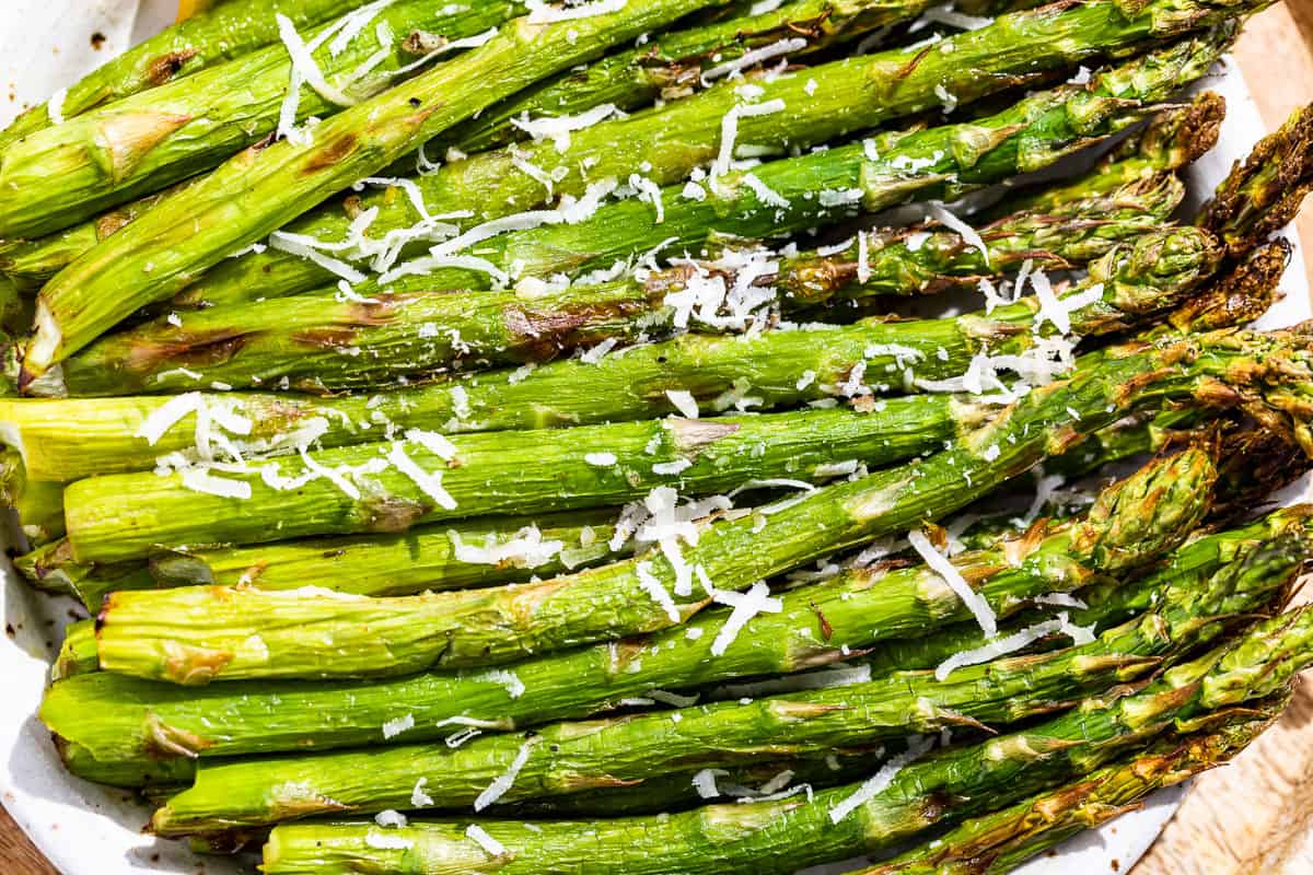 Close macro view of air fryer asparagus sprinkled with grated parmesan.