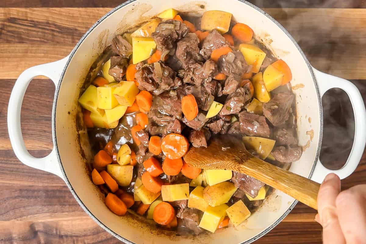 Mixing in the carrots and potatoes to the beef stew mixture.