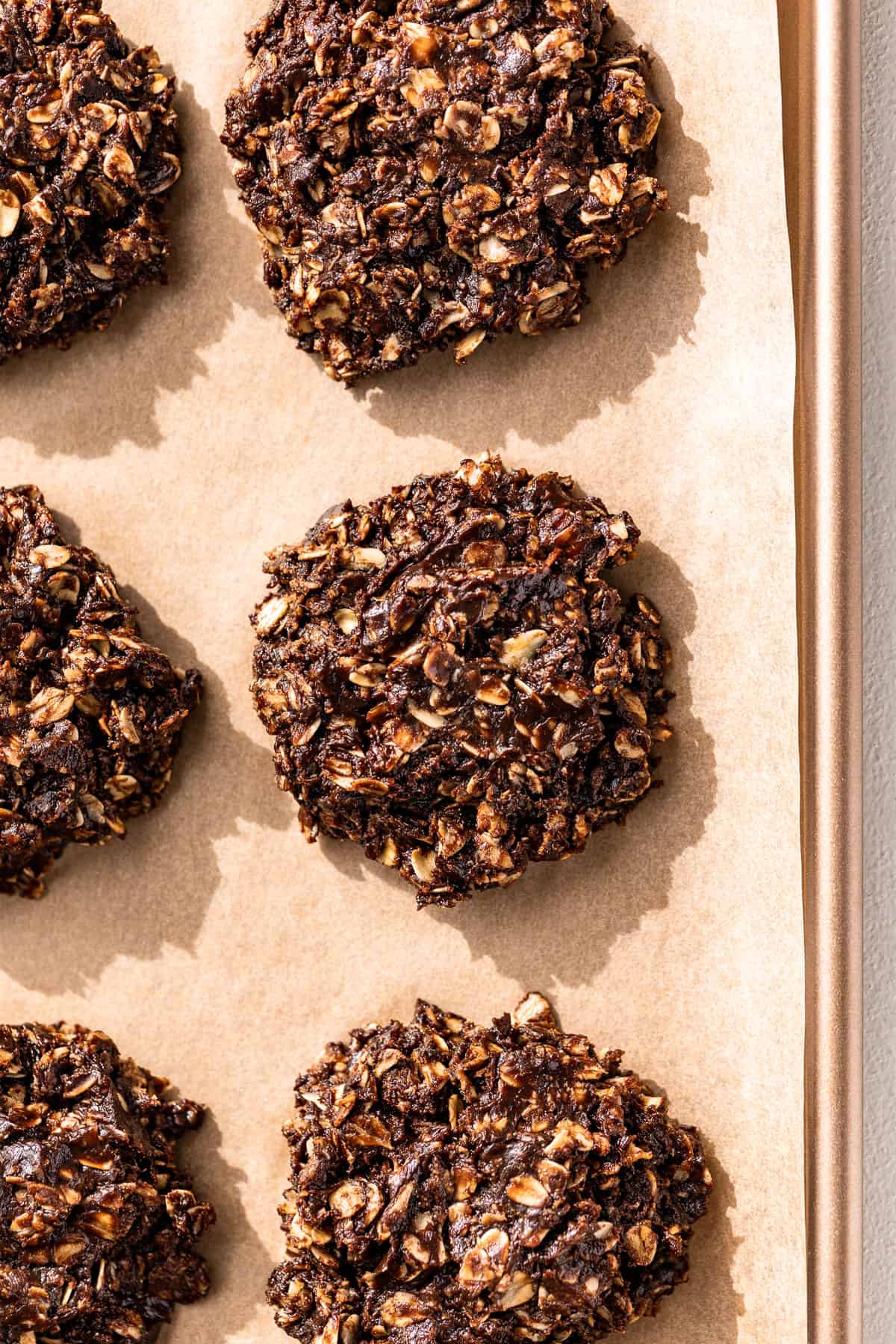 Portioned out no bake cookies on a parchment lined baking sheet.