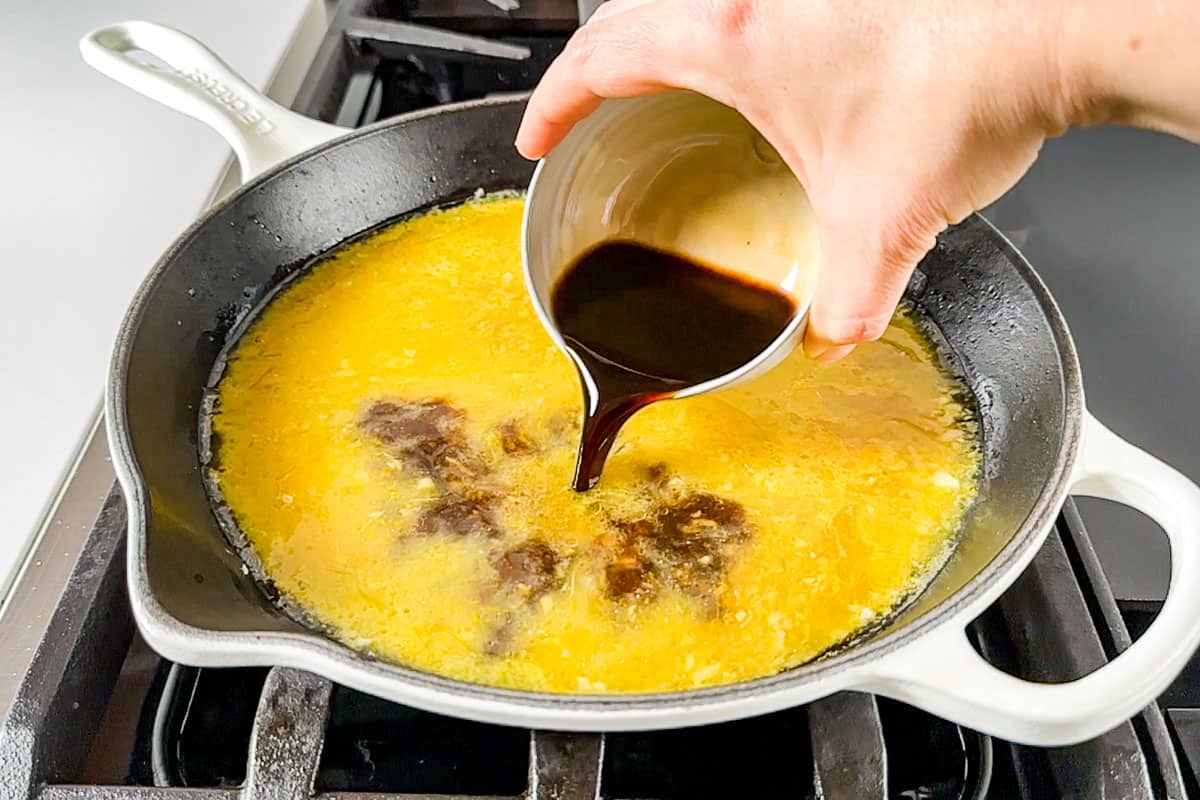 Adding the orange juice, orange zest, and coconut aminos to the cast iron skillet.