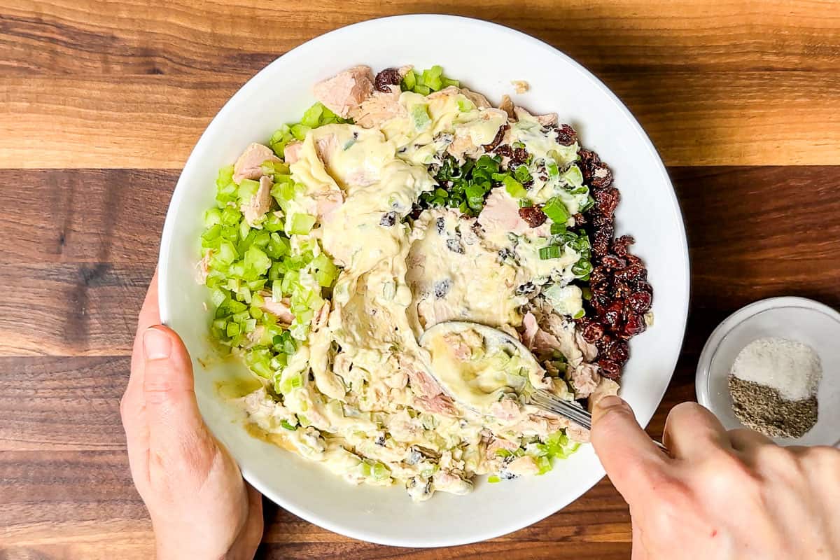 Adding the mayonnaise and Dijon mustard to the tuna salad.